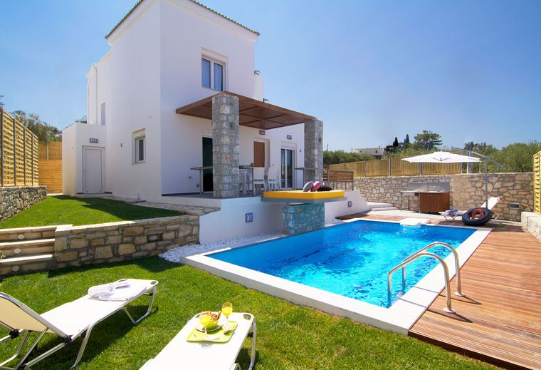 Pool und Sonnenliegen der Villa Aada bei Tag