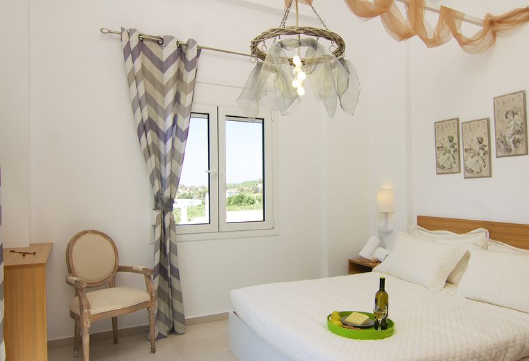 Schlafzimmer der Villa Aada mit Doppelbett und Blick ins Grüne