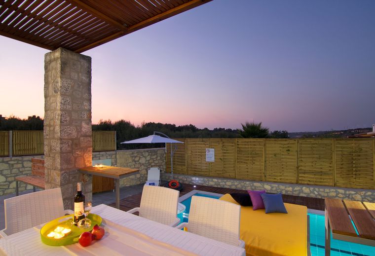 Gedeckter Tisch auf der überdachten Terrasse der Villa Aada in der Dämmerung