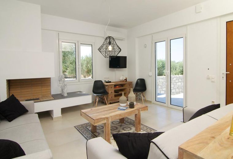 Heller Wohnraum der Villa Aada mit Kamin und Sitzgruppe