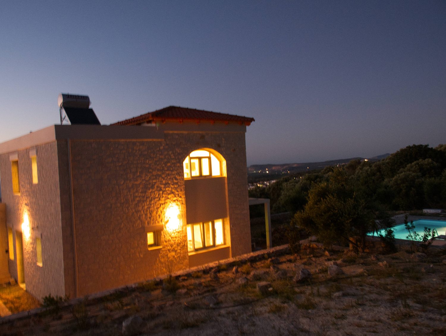Villa Eos in der Abenddämmerung mit beleuchteten Fenstern
