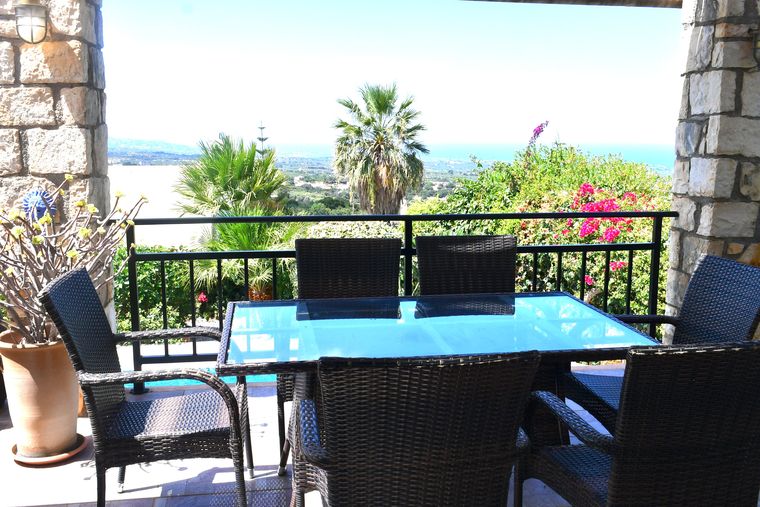 Terrasse der Villa Mailin mit gedecktem Tisch und Blick über Palmen zur Küste